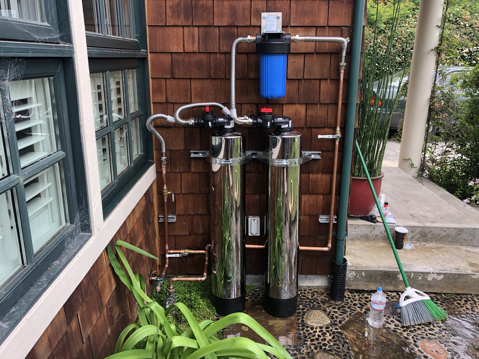 Plumber repairing a leaking pipe under a sink in a Santa Cruz County home, showcasing professional plumbing service.