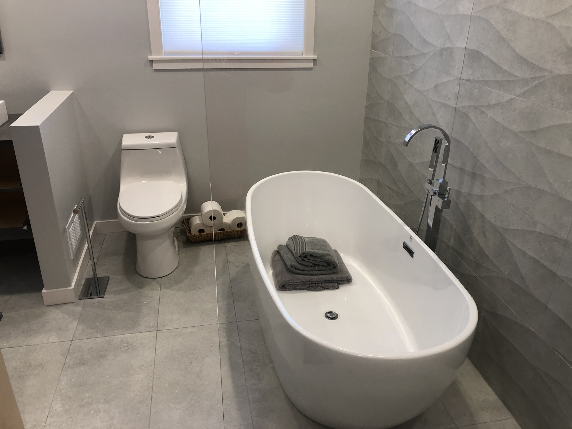 Plumber repairing a leaking pipe under a sink in a Santa Cruz County home, showcasing professional plumbing services.
