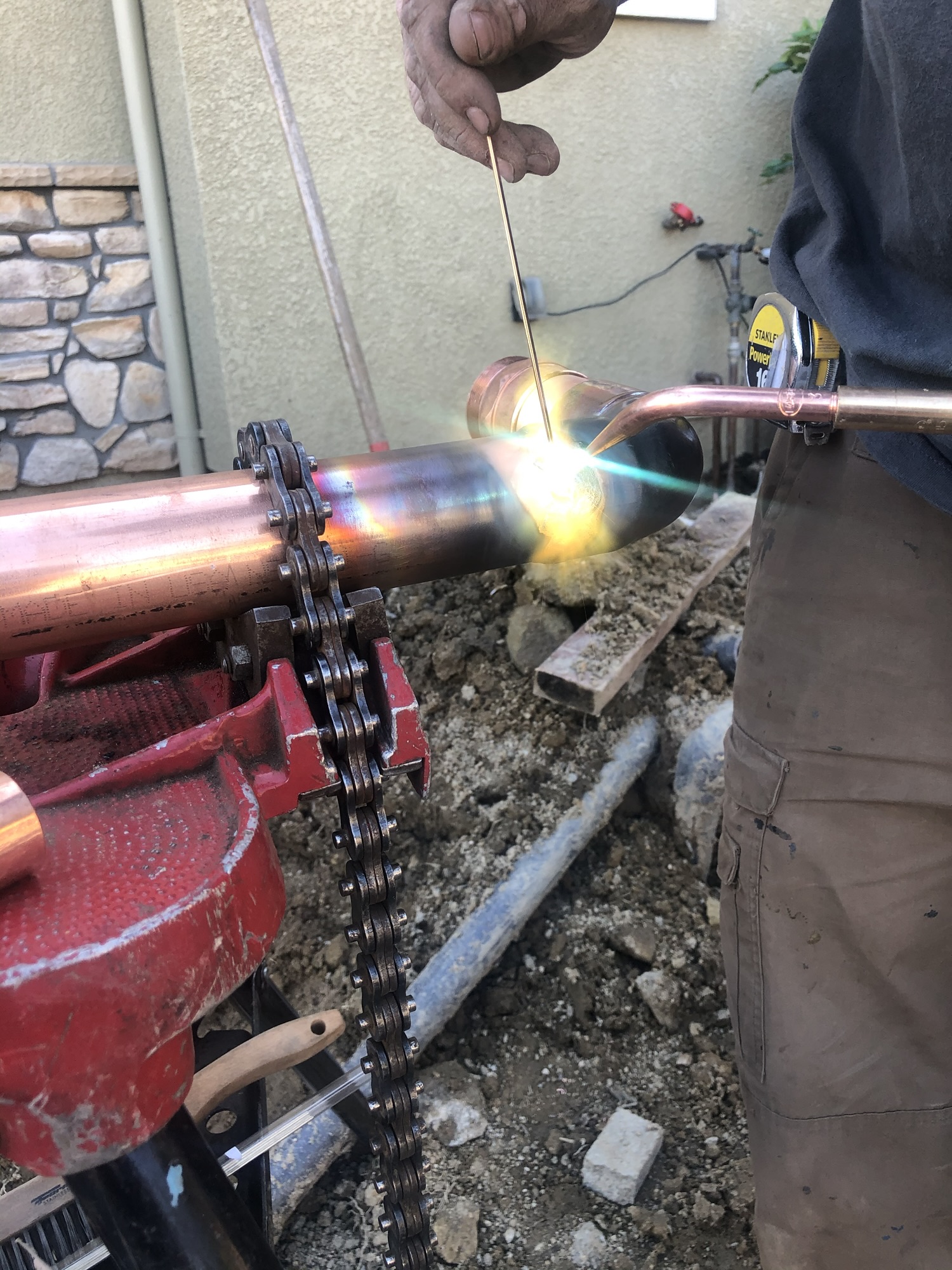 Plumber inspecting a septic tank with tools in Santa Cruz County, California.